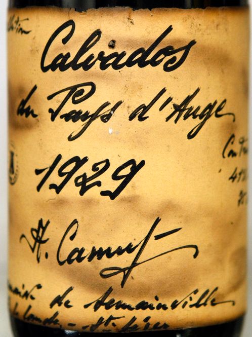 En håndskrevet etikett på en flaske calvados fra 1929. Foto.