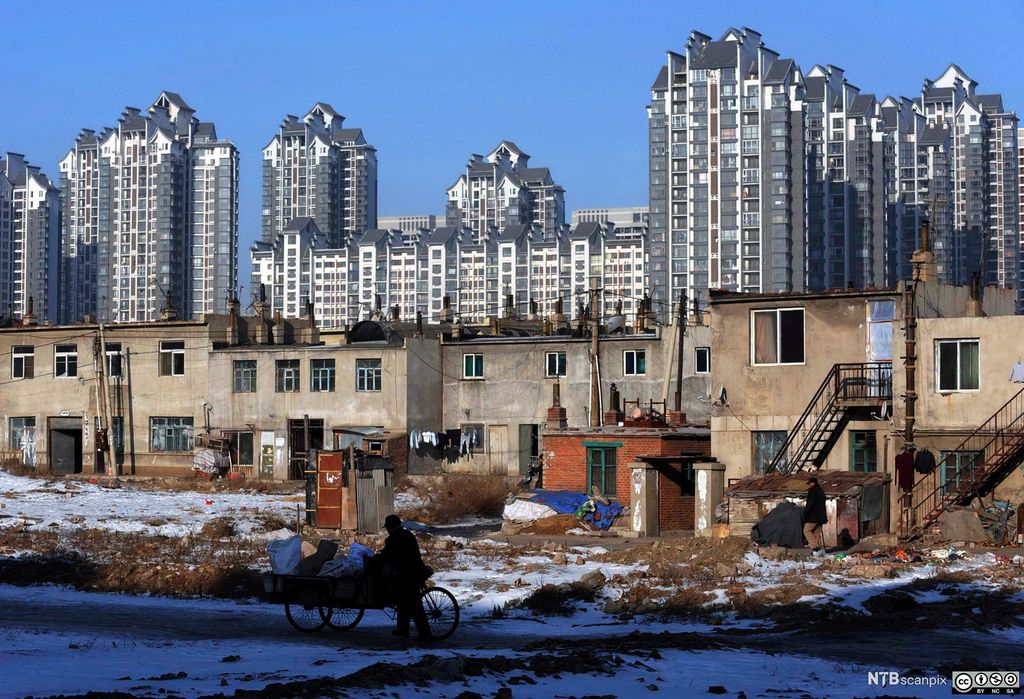 Nye skyskrapere reiser seg i bakgrunnen av et eldre boligkvarter i Kina. Foto.
