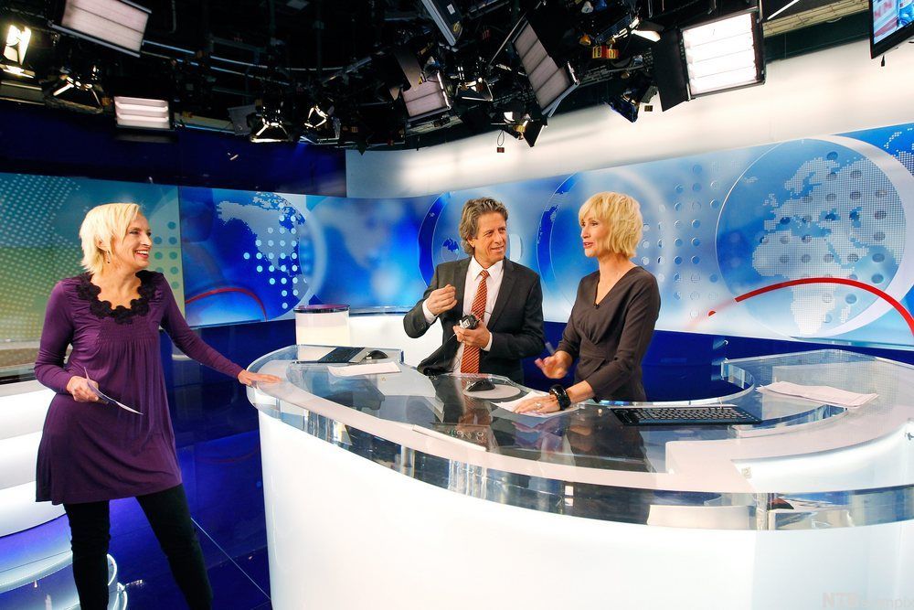 Sportsanker Karen-Marie Ellefsen lener seg mot bordet i Dagsrevy-studioet. På andre sida står nyheitsankera Nina Owing og Knut Olsen. Foto.