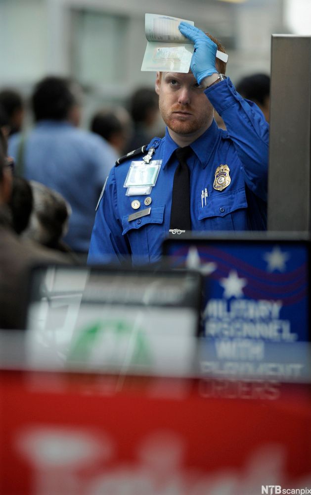Tollbetjent holder opp et dokument. Foto.