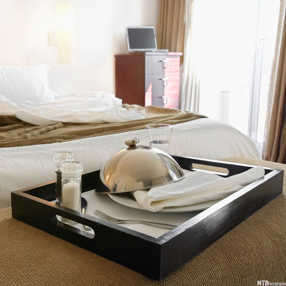 Et serveringsbrett står på sengen på et hotellrom. Foto.