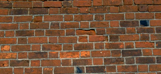 Ein vegg som er mura med raud teglstein. Foto.