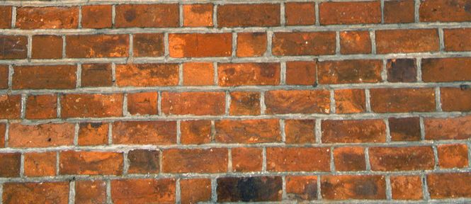 Murvegg av teglsteinar lagde i forband. Foto.