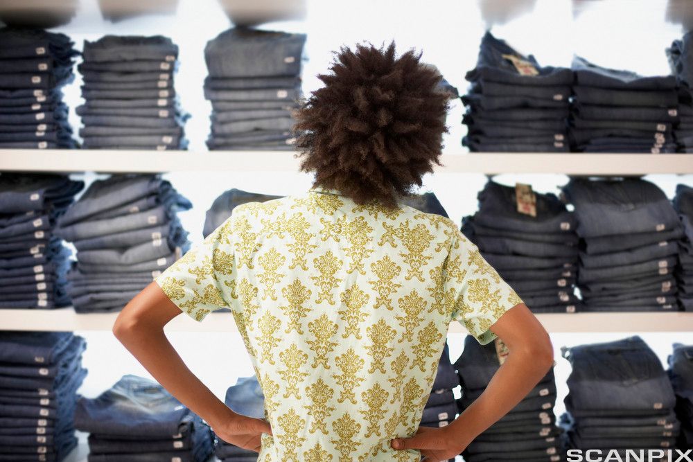 En person ser på bukser i en butikk. Foto.