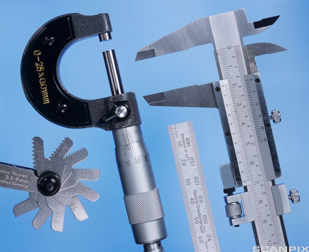 Ulike metalliske måleverktøy: gjengemåler, mikrometer, linjal og skyvelære. Foto.