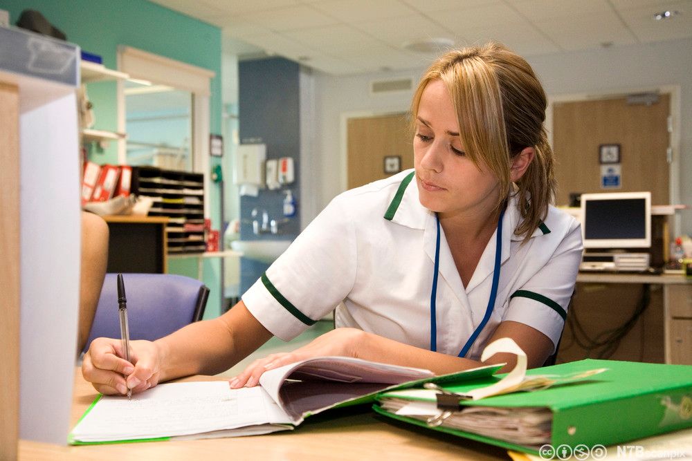 Helsearbeider fyller ut dokumenter. Foto.