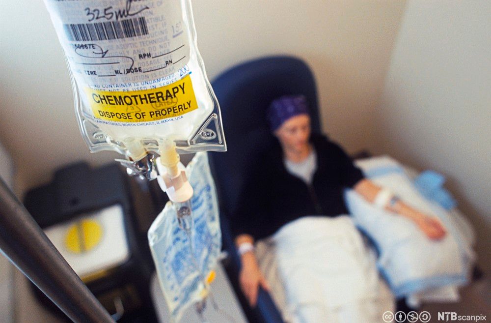 Pasient sitter i en stol og mottar cellegift intravenøst. Foto.