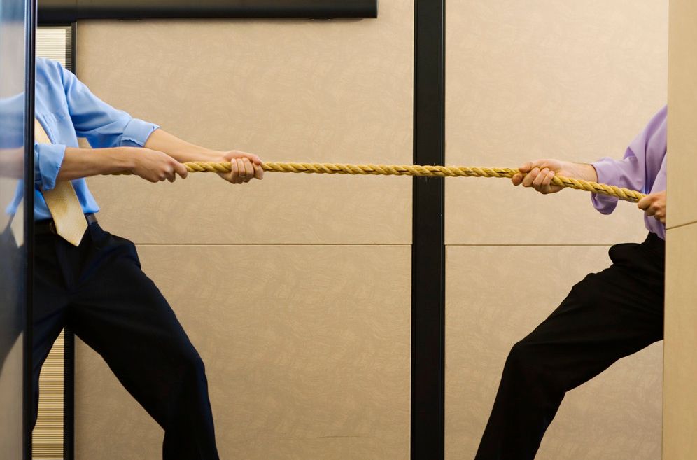 To personer trekker i hver sin ende av et tau. Foto.