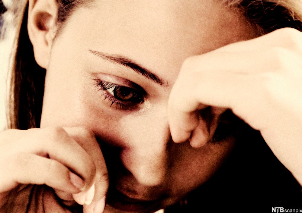 Bilde av ung jente med trist uttrykk i ansiktet.Foto.