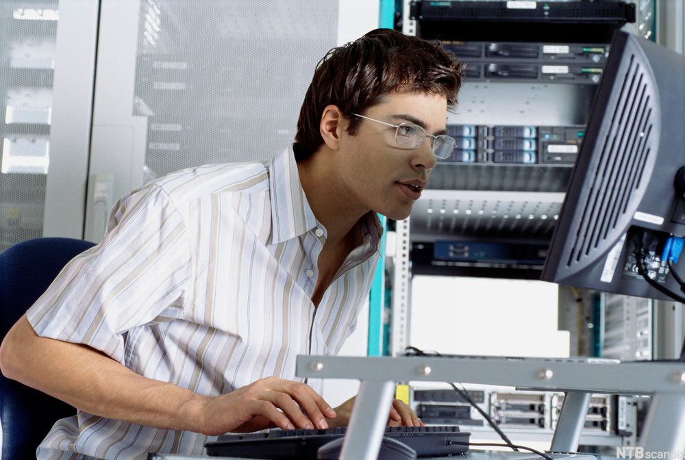 Mann som studerer innholdet på en dataskjerm. Foto.