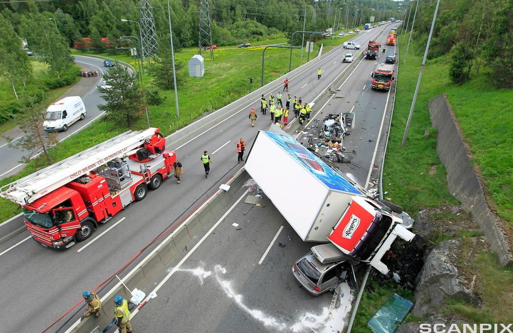 Ulykke der et vogntog har kollidert med en passasjerbil. Nødetatene har ankommet skadestedet. Foto.