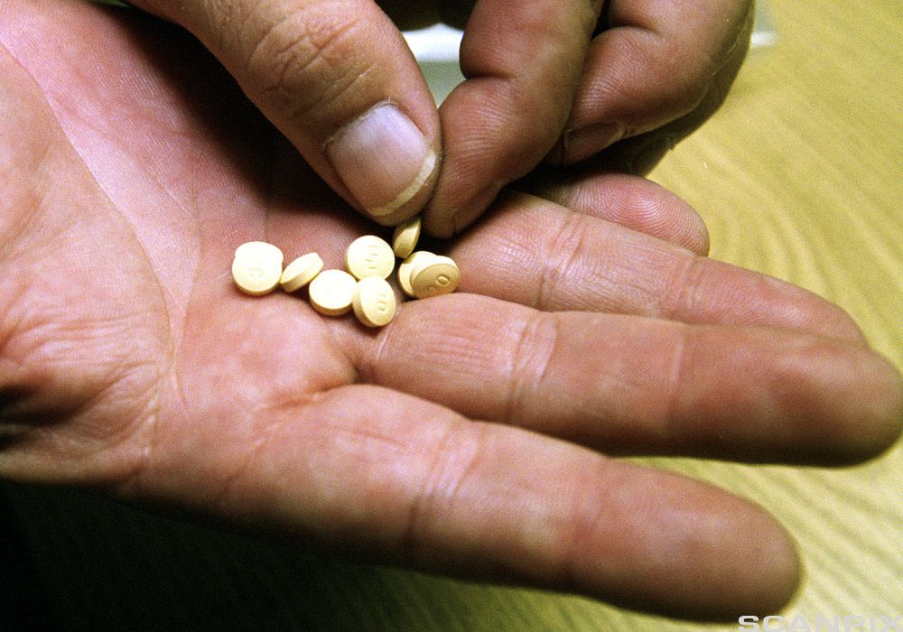 Hånd med tabletter. Foto.