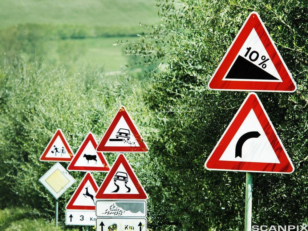 Foto av flere trekantede fareskilt. 