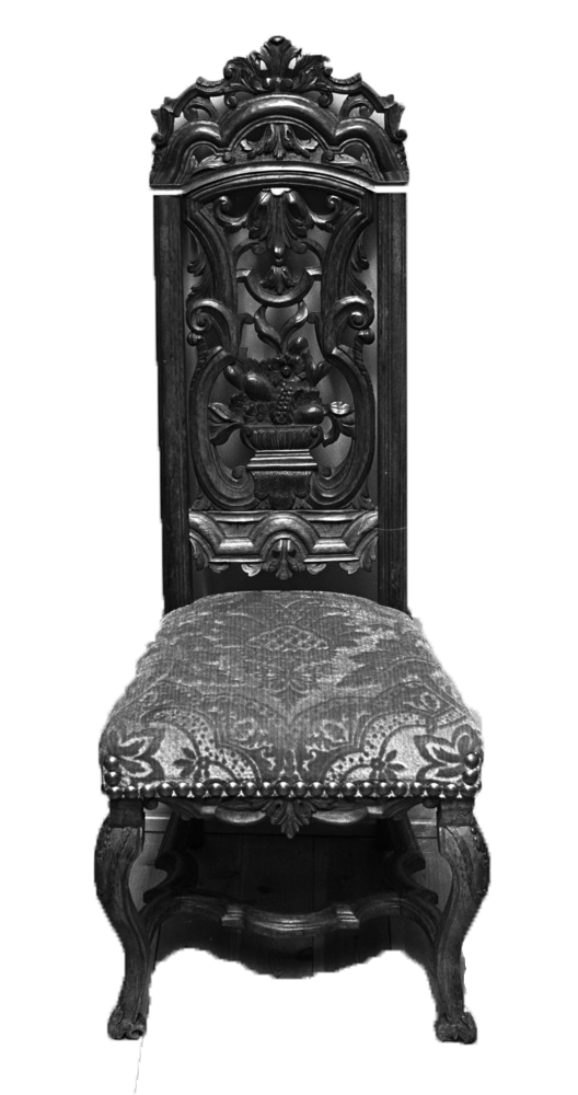 Sort stol med trekk i skåret fløyel, utskjæringer i ryggen og buede ben. Foto.