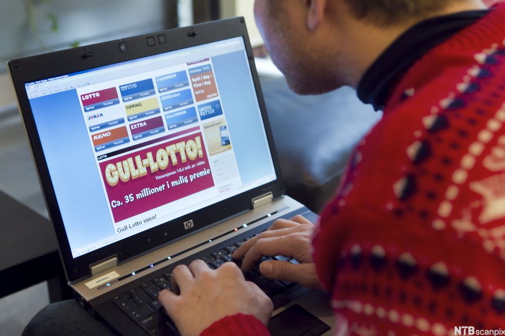 Bilde av en mann som sitter ved en bærbar datamaskin og ser på nettstedet til Norsk Tipping. På skjermen ser vi logoene til ulike spill fra Norsk Tipping. Foto.