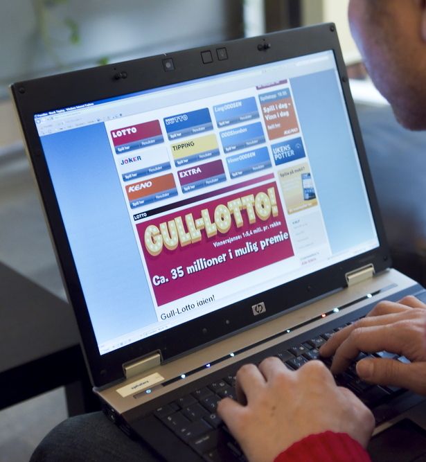 Ein mann sit framfor ein berbar pc og ser på nettsida til Norsk Tipping. Foto.