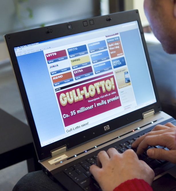En mann sitter foran en laptop og ser på hjemmesiden til Norsk Tipping. Foto.