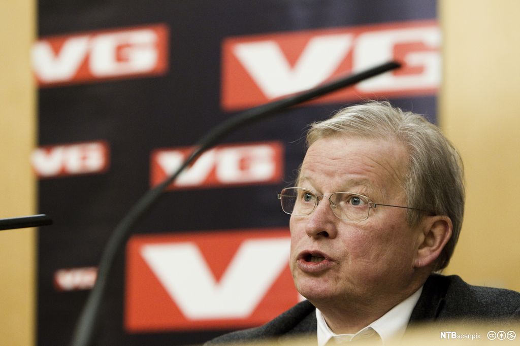 Portrett av mann foran VG-logo. Foto.