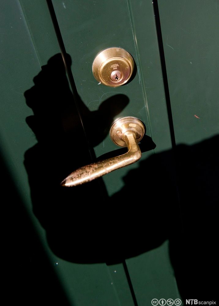 Bilete av skuggen av ein innbrotstjuv som nærmar seg ei dør. Foto.