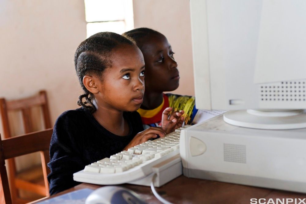 Afrikanske skolejenter jobber på PC. Foto.