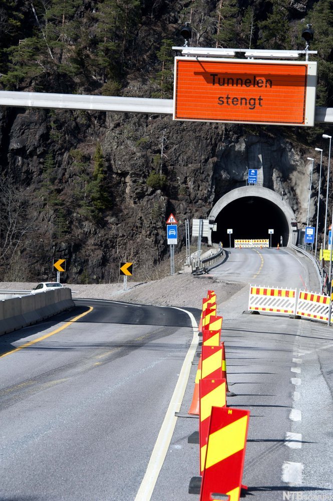 En veitunnel som er stengt for trafikk, og en omkjøringsvei som går til venstre for tunnelen. Foto.