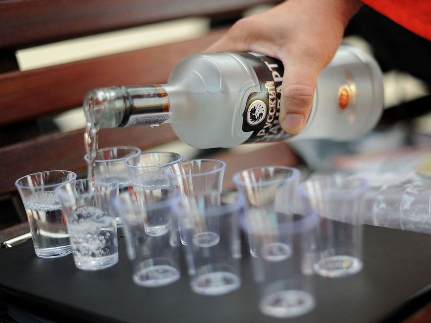 Skjenking av russisk vodka i shotglass. Foto.