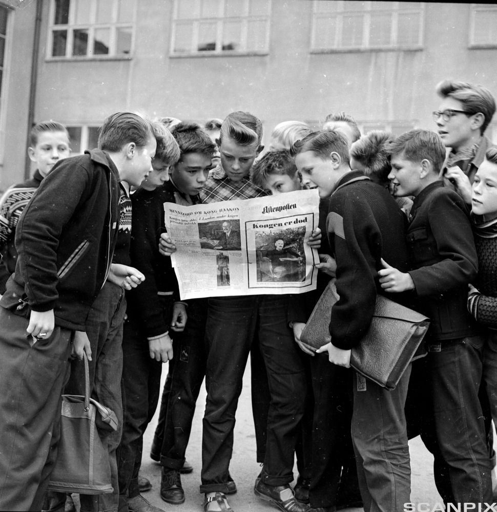 Gammelt svart-hvitt-bilde av skolebarn som leser Aftenpostens ekstrautgave i skolegården. Foto.