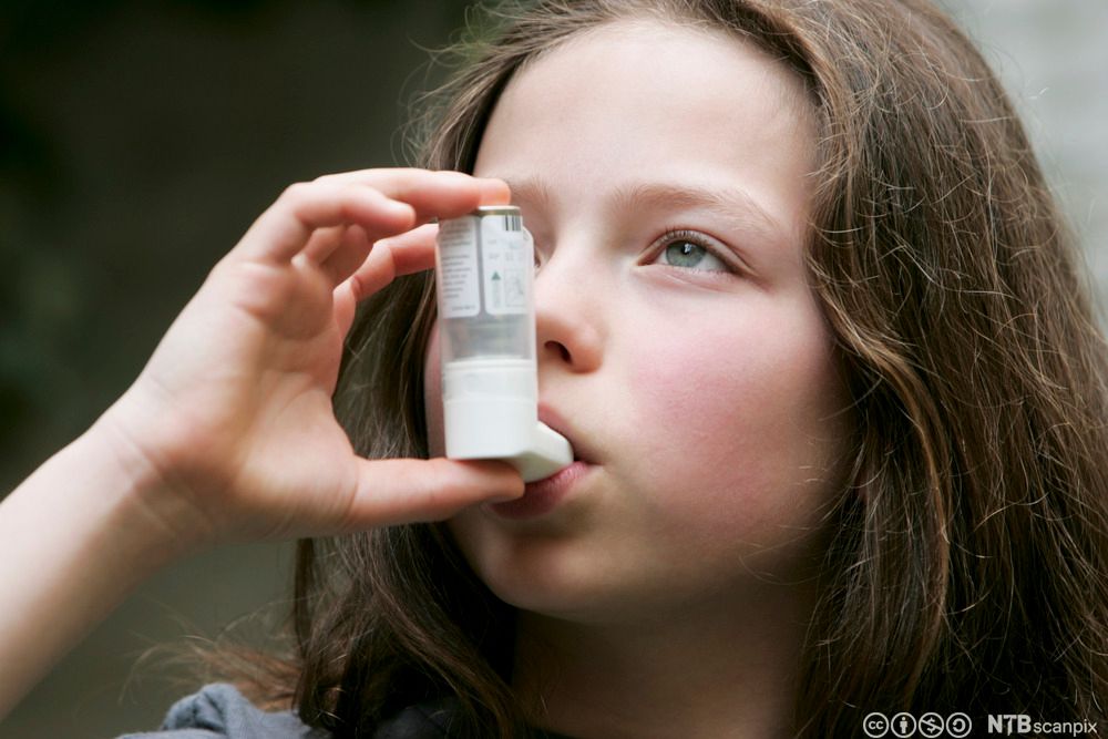 Jente som tar astmamedisin. Foto.