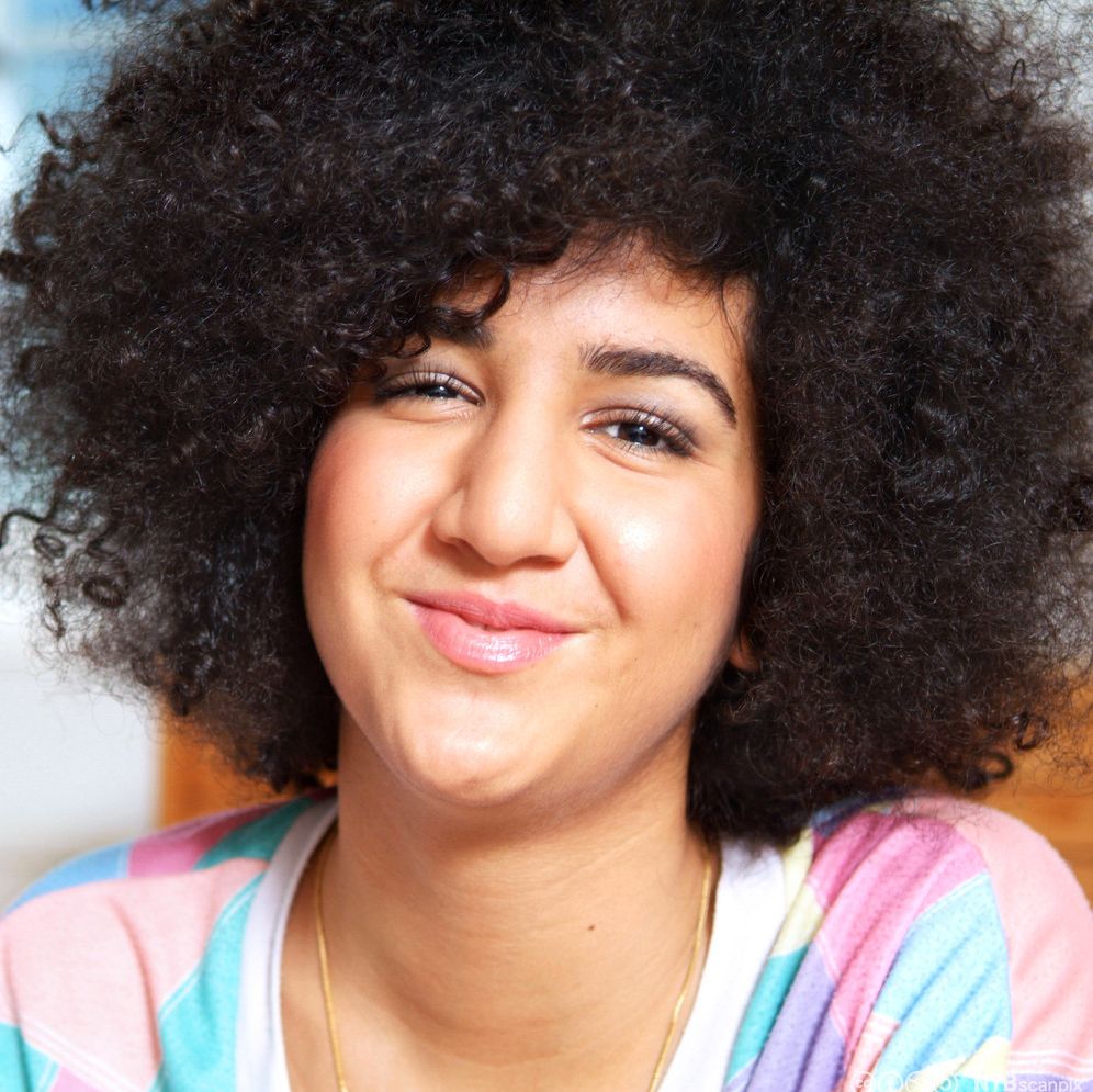 Portrett av jente med stort krøllete hår. Foto.