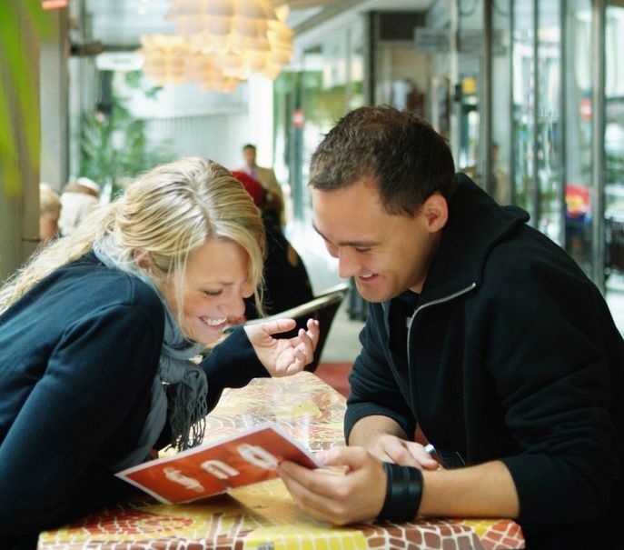 Mann og kvinne sitter på restaurant og studerer en meny. Foto.