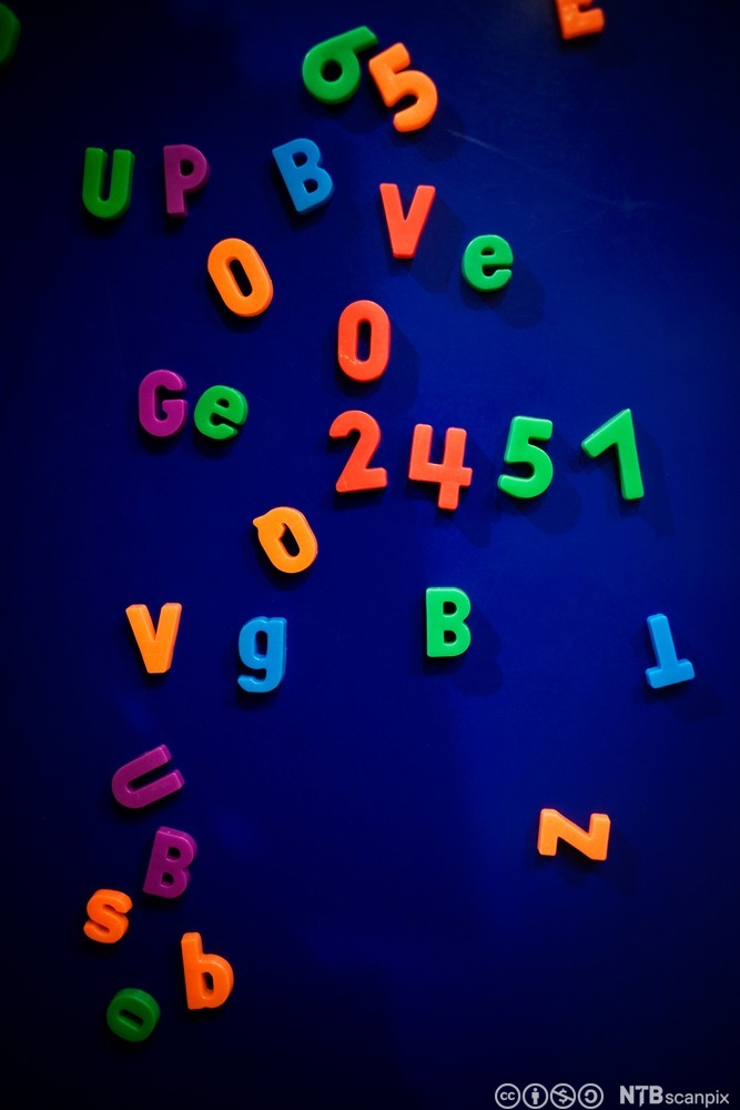 Magneter formet som tall og bokstaver, i forskjellige farger. Foto.
