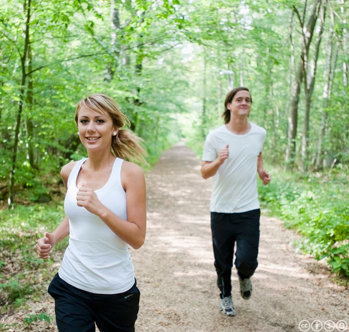 To ungdommar joggar i skogen. Foto.