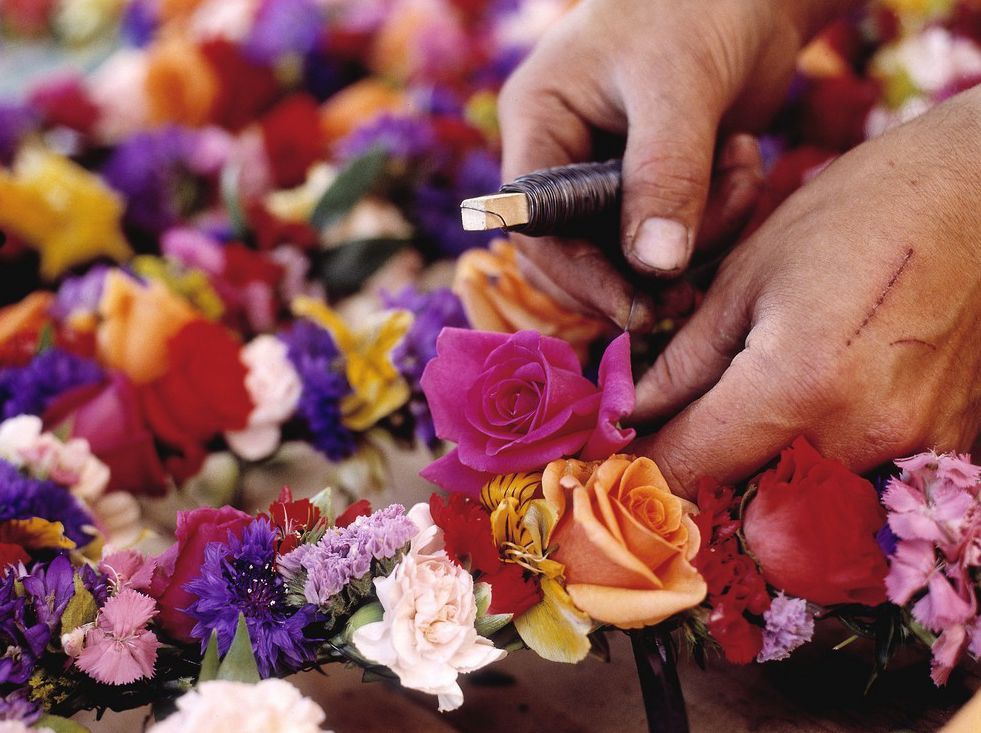 Blomster bindes sammen med ståltråd. Foto.