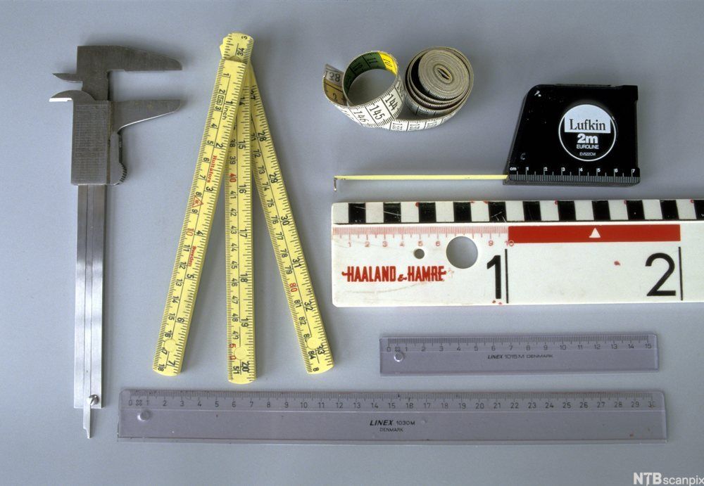 Ulike instrumenter til lengdemåling: skyvelære, tommestokk, skreddermålebånd, målebånd og tre linjaler i ulike størrelser. Foto.