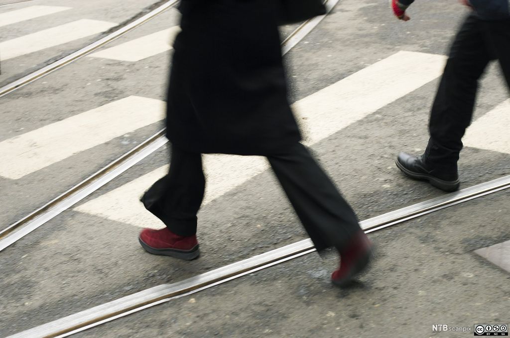 Personer krysser trikkespor. Foto.