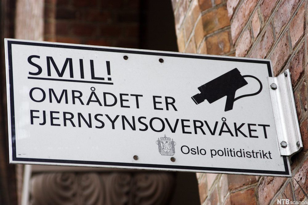 Skilt med tekst Smil! Området er fjernsynsovervåket. Oslo Politidistrikt. Foto. 
