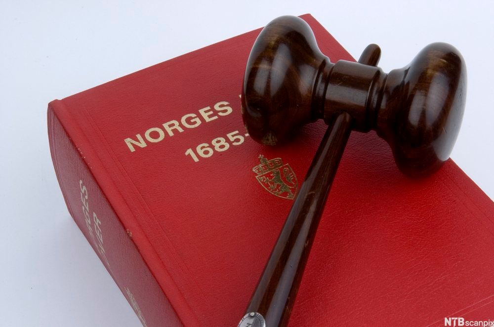 Norges lover med en klubbe liggende oppå. Foto.