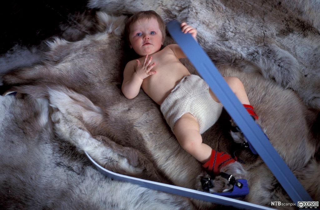 Baby med ski på beina. Foto.