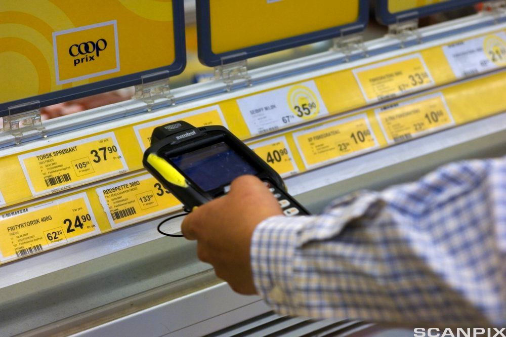 Butikkansatt holder strekkodeleser mot varekoder på frysedisk.foto.
