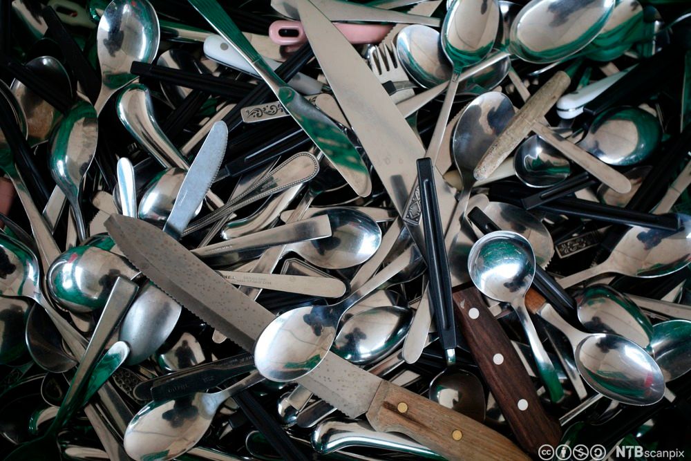 Masse forskjellig bestikk ligger i en haug uten system eller orden. Foto.