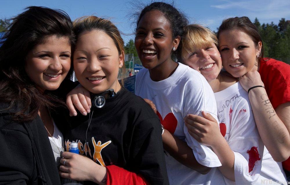 Fem unge, glade jenter med ulik etnisk bakgrunn. Foto.