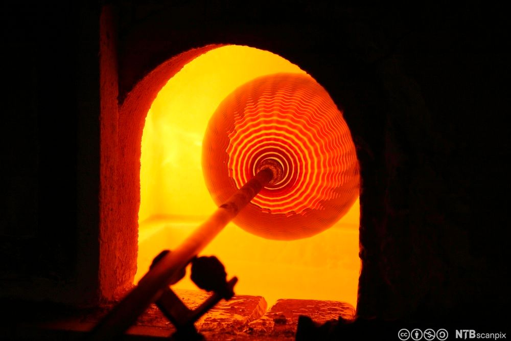 Rødglødende glass i smelteovn. Foto.
