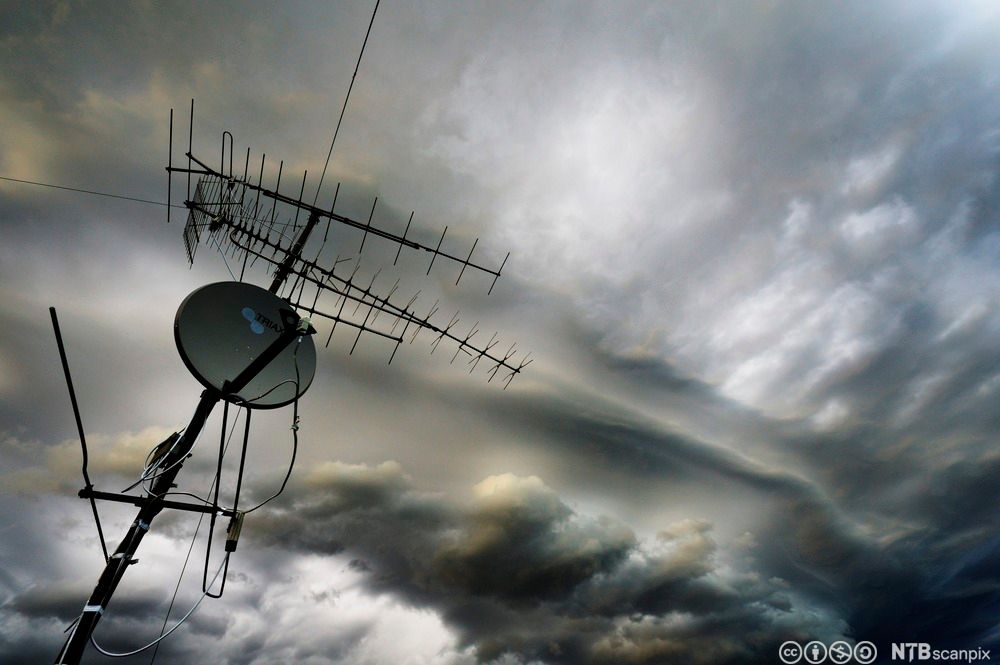Antenne og parabol på hustak. Foto.