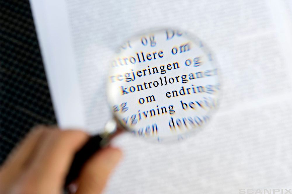 Forstørringsglas over tekst. Foto. 