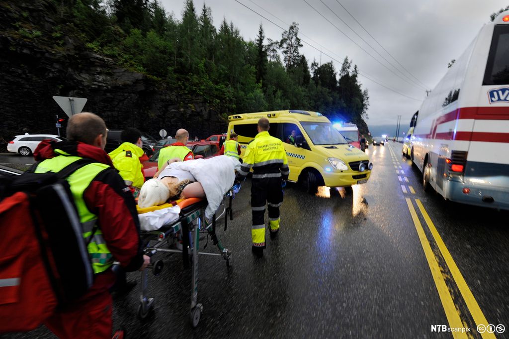 Skadet person fraktes bort på båre av helsepersonell. Foto.