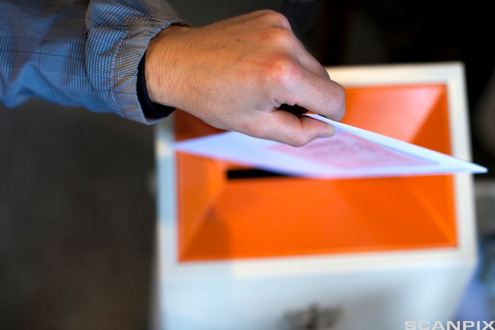 Stemmeseddel puttes i urne. Foto.