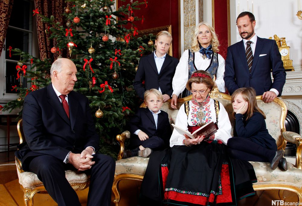 Hele kongefamilien foran juletreet. Sonja leser eventyr for barna.