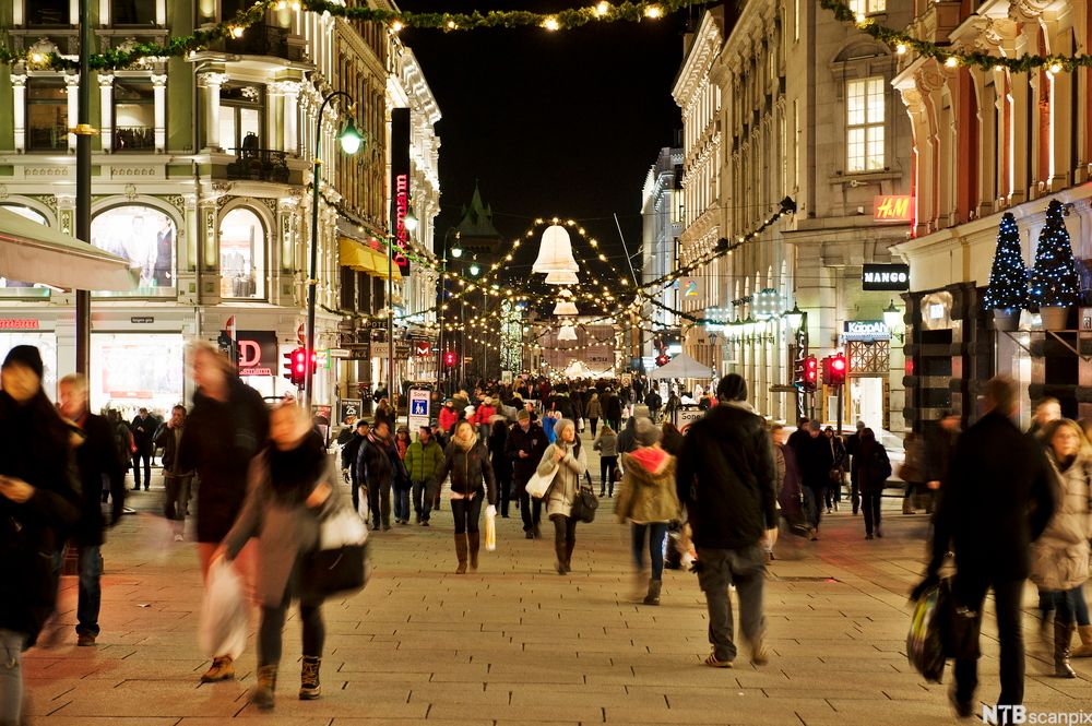 Mennesker som går i ei travel gate. Foto.