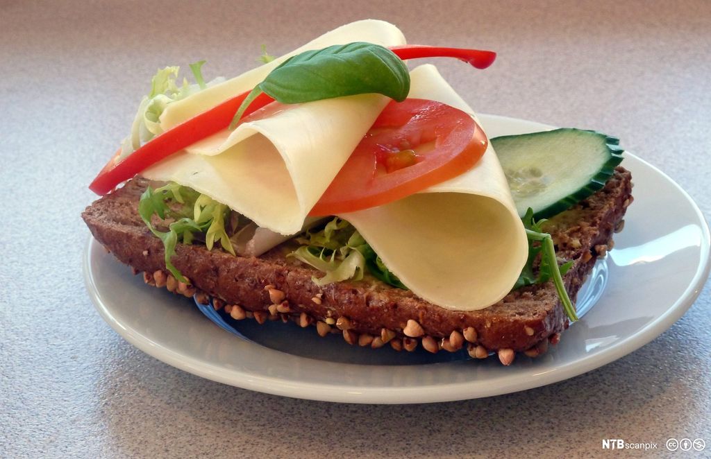 Grovt rundstykke med gulost. Foto.