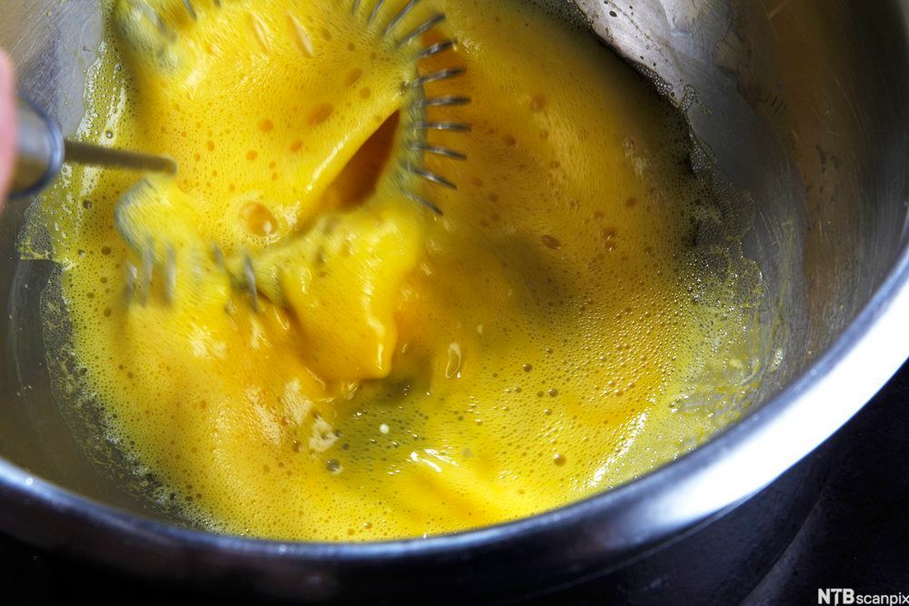 Egg pisket i en metallbolle. Foto.
